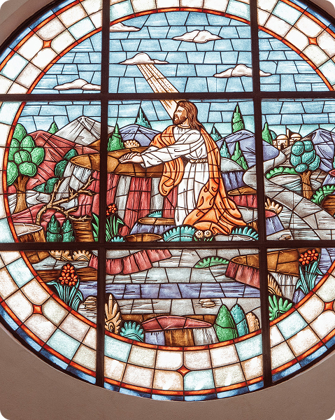 Stained glass window of Jesus praying